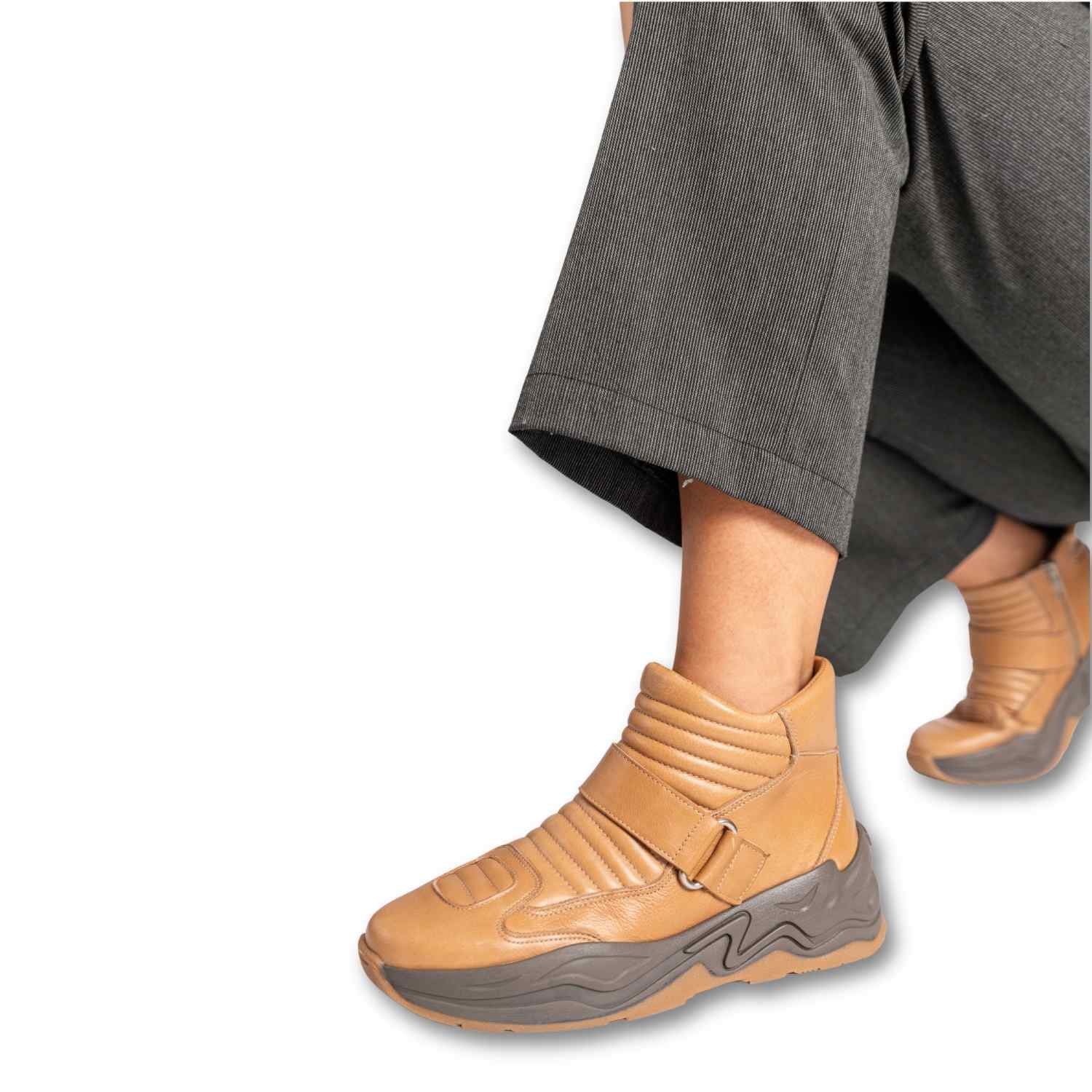 Tan high-top sneakers worn with gray pants